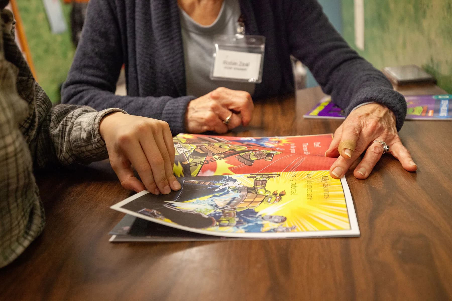 A student and volunteer sharing a book during a ROW session